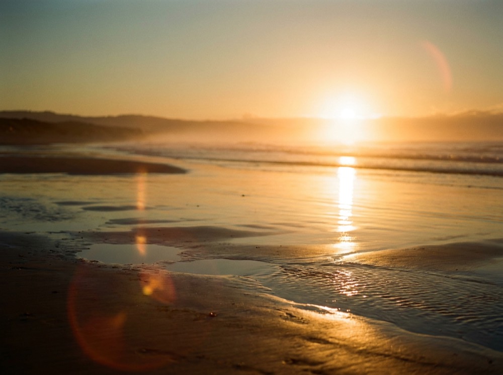 Low sun breaking over a calm ocean horizon at dawn